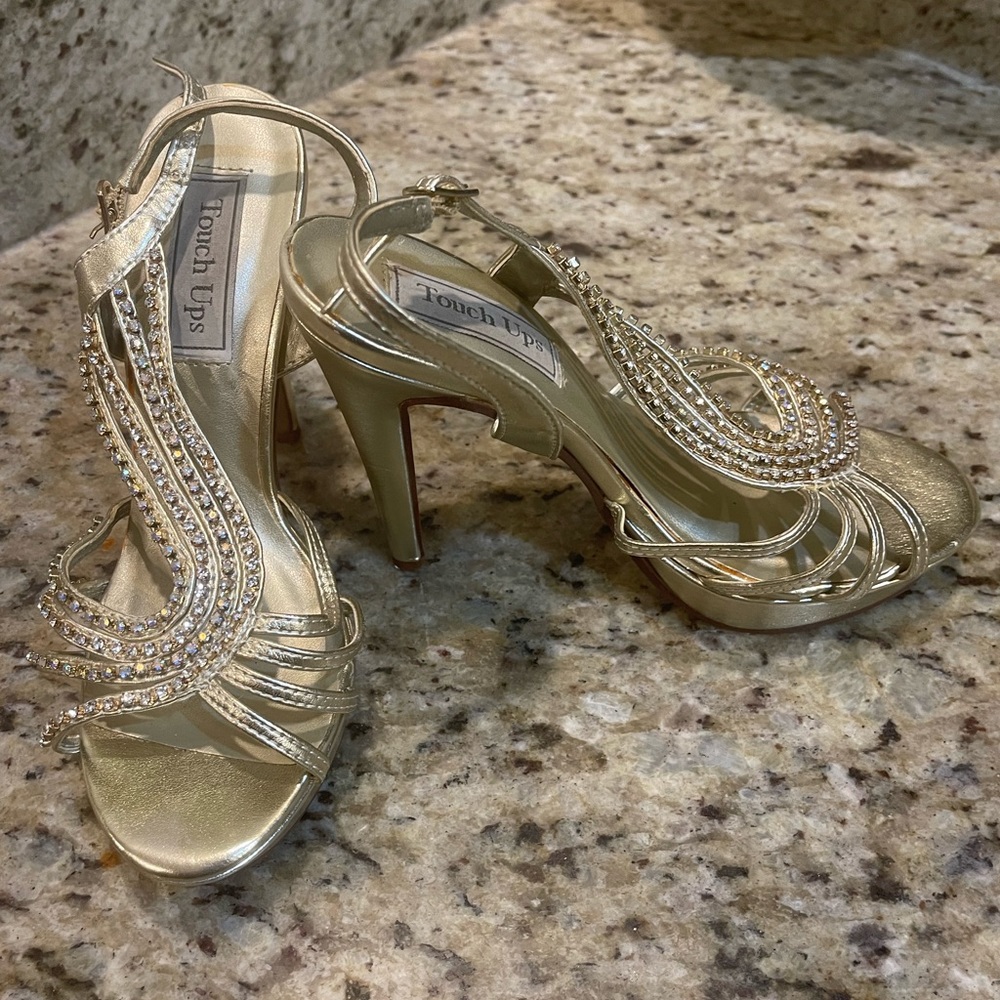 Gold high heels with open sides and rhinestone decoration